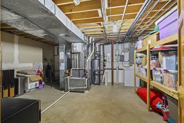 unfinished below grade area featuring heating unit, washer / dryer, electric panel, and gas water heater