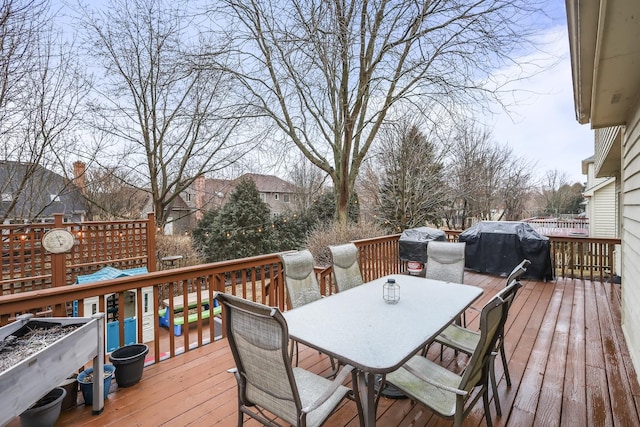 wooden terrace with outdoor dining space and a grill