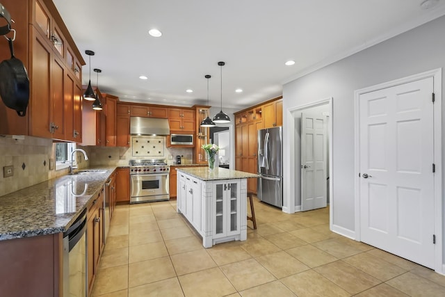 kitchen with dark stone counters, appliances with stainless steel finishes, a sink, under cabinet range hood, and backsplash