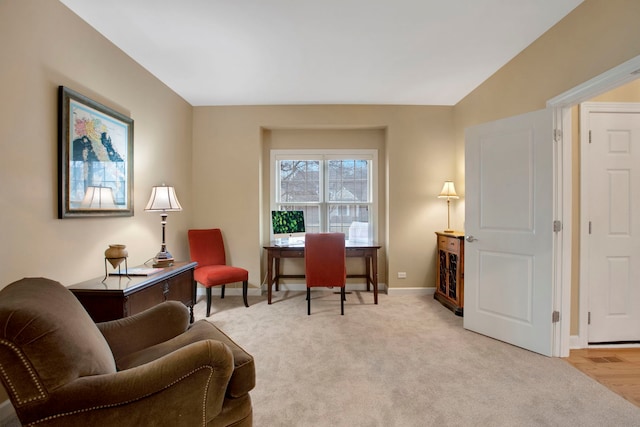 living area featuring light colored carpet and baseboards