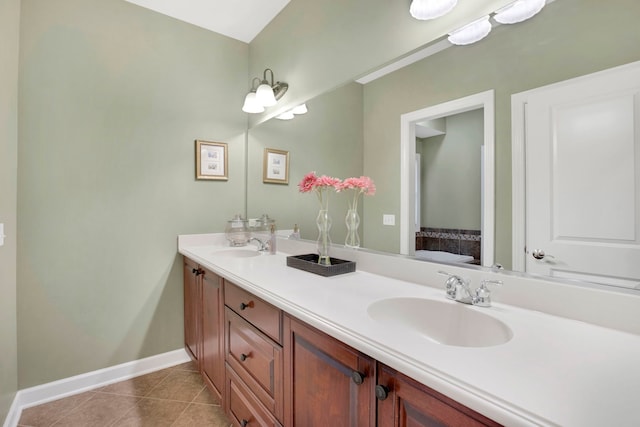 full bathroom with tile patterned floors, double vanity, baseboards, and a sink