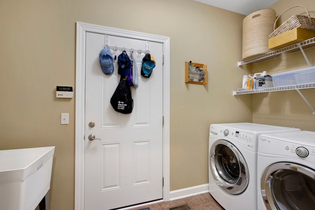 laundry room featuring baseboards, washer and clothes dryer, laundry area, tile patterned floors, and a sink