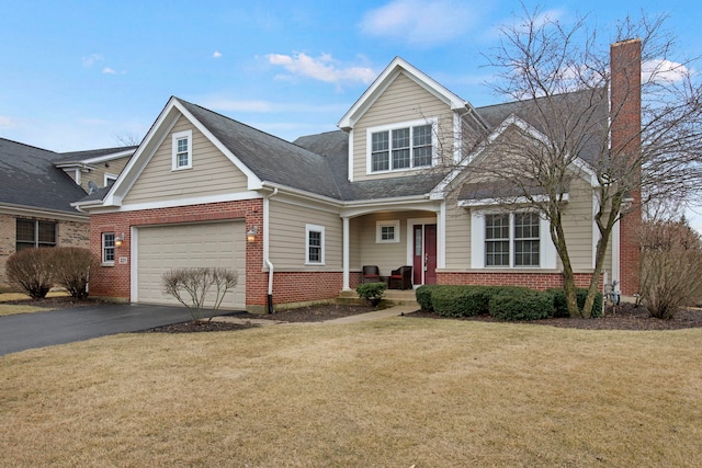 view of front of home featuring a front yard, a chimney, a garage, aphalt driveway, and brick siding