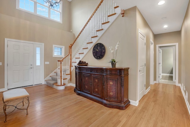 entrance foyer featuring baseboards, light wood-style flooring, and stairs