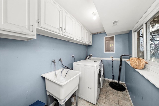 washroom featuring cabinet space, visible vents, a sink, separate washer and dryer, and baseboards