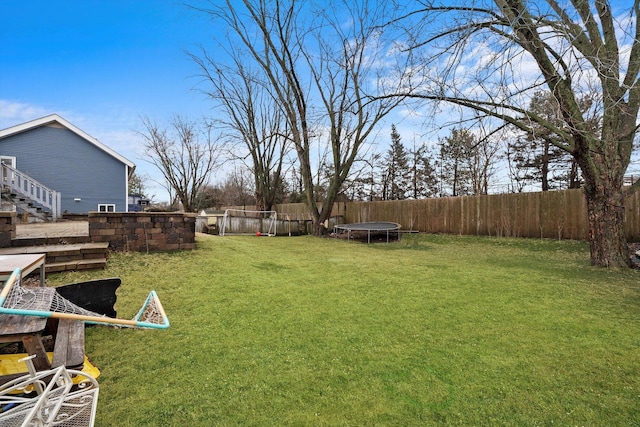 view of yard featuring a fenced backyard and a trampoline