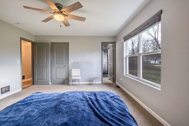 bedroom with a ceiling fan, visible vents, baseboards, and carpet flooring