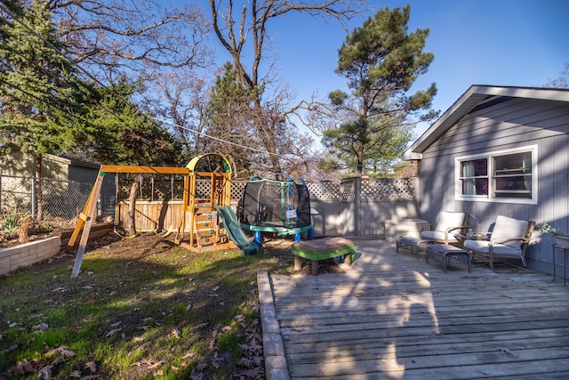 deck with a trampoline, fence, and a playground