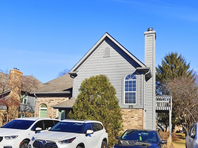 view of home's exterior with brick siding and a chimney