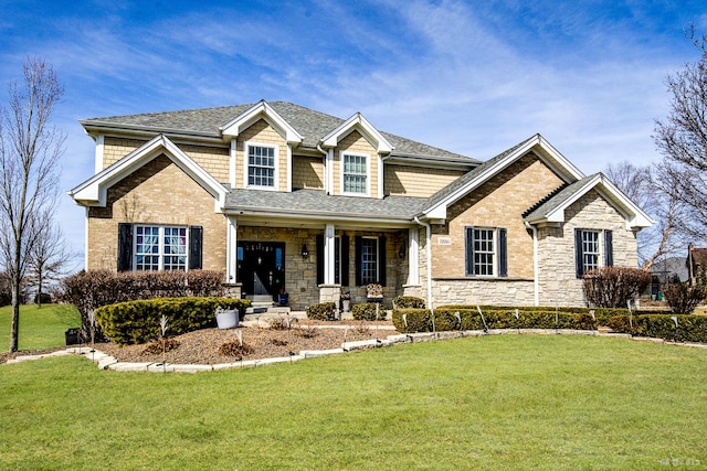 craftsman inspired home featuring stone siding, a porch, a front yard, and a shingled roof