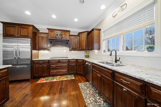 kitchen featuring ornamental molding, a sink, backsplash, stainless steel appliances, and dark wood-style flooring