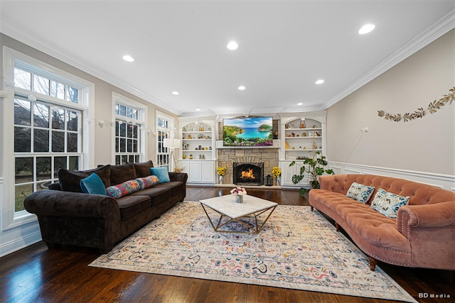 living area featuring a stone fireplace, recessed lighting, wood finished floors, and ornamental molding