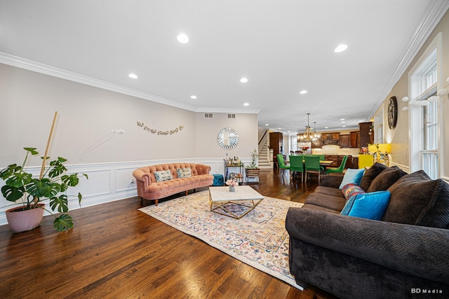 living area featuring stairway, ornamental molding, recessed lighting, wood finished floors, and a decorative wall