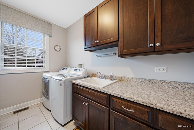 laundry room featuring visible vents, independent washer and dryer, a sink, cabinet space, and light tile patterned floors