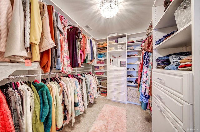 walk in closet with a notable chandelier, carpet flooring, and visible vents