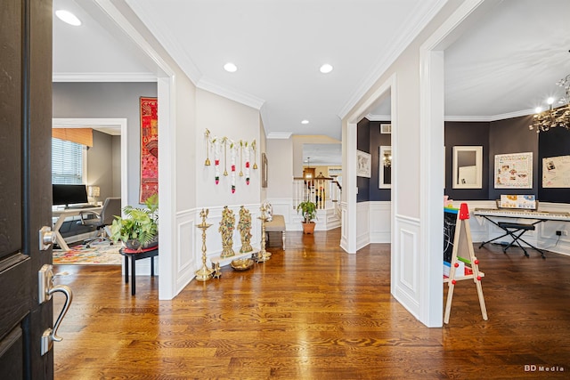 hallway featuring wood finished floors, recessed lighting, an inviting chandelier, wainscoting, and stairs