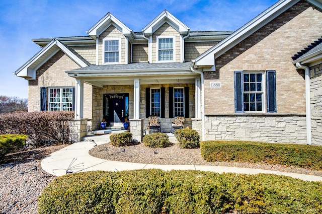 view of front of home with a porch and stone siding