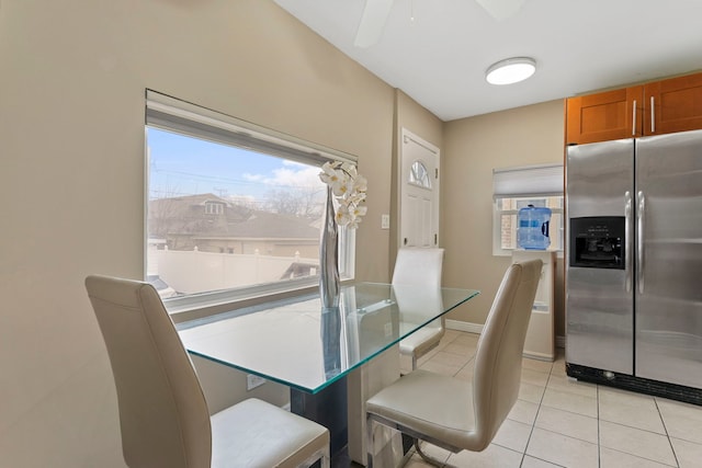 dining space featuring light tile patterned floors, baseboards, and a ceiling fan