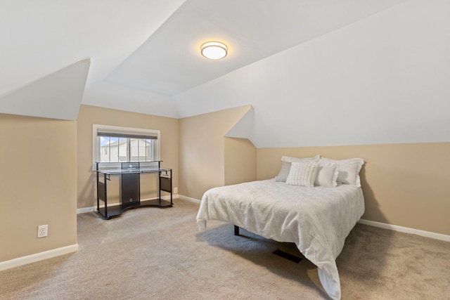 carpeted bedroom featuring baseboards and lofted ceiling