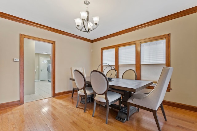 dining space with crown molding, a notable chandelier, baseboards, and light wood-type flooring