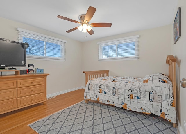 bedroom with light wood finished floors, ceiling fan, and baseboards