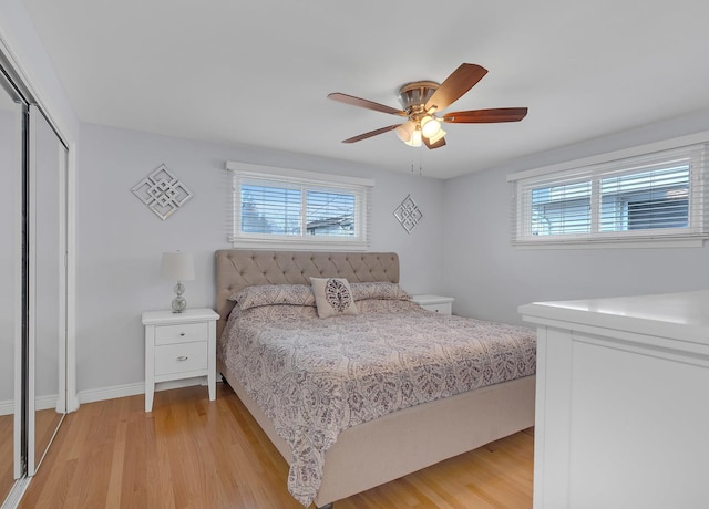 bedroom featuring multiple windows, light wood-type flooring, and a closet