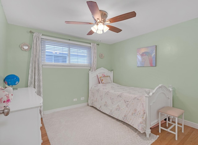 bedroom with ceiling fan, wood finished floors, and baseboards