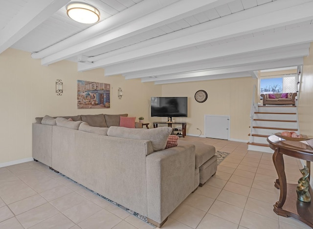 living room with light tile patterned floors, stairs, baseboards, and beam ceiling