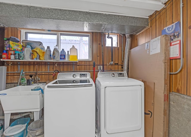 washroom featuring laundry area, washer and clothes dryer, and a sink