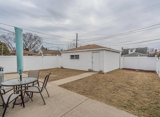 view of patio with outdoor dining area, a fenced backyard, and an outdoor structure