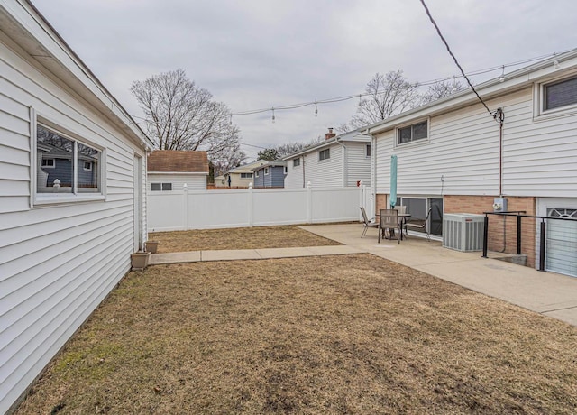 view of yard featuring fence, central AC, and a patio