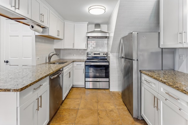 kitchen with stainless steel appliances, wall chimney range hood, a sink, tasteful backsplash, and white cabinets