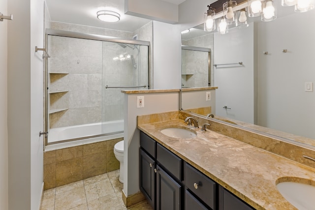 full bathroom with double vanity, tile patterned floors, toilet, and a sink