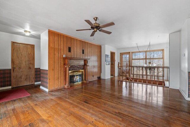 11040 W Cleveland Rd, Mokena, IL 60448 - unfurnished living room with wood finished floors, a ceiling fan, a glass covered fireplace, baseboards, and wooden walls
