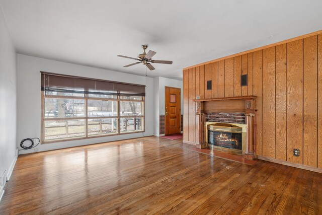 11040 W Cleveland Rd, Mokena, IL 60448 - unfurnished living room with a fireplace, a ceiling fan, wood finished floors, baseboards, and wood walls
