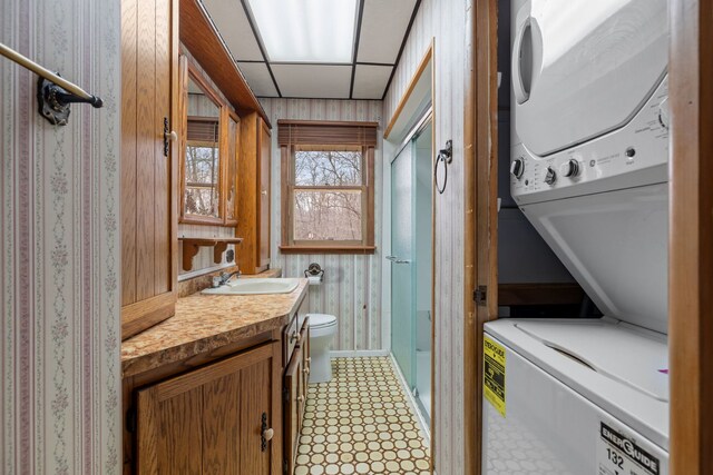 11040 W Cleveland Rd, Mokena, IL 60448 - bathroom featuring stacked washing machine and dryer, a shower stall, toilet, vanity, and baseboards