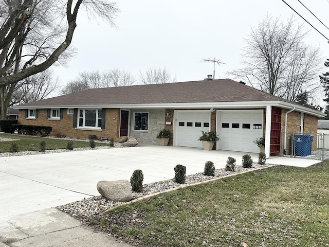 ranch-style home featuring driveway, roof with shingles, an attached garage, and a front yard