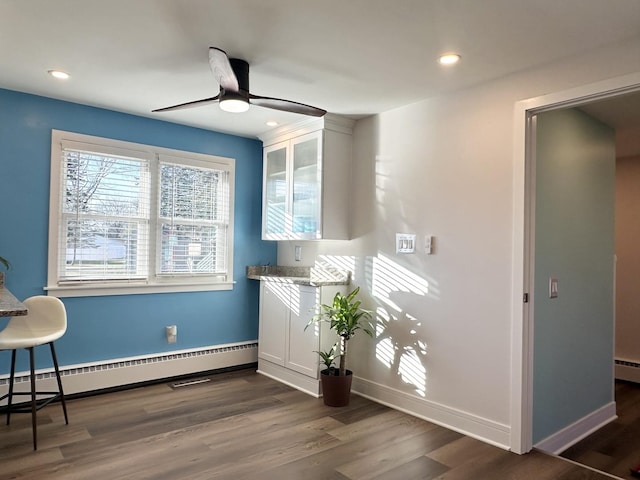 interior space with a baseboard radiator, recessed lighting, a ceiling fan, baseboards, and dark wood-style floors