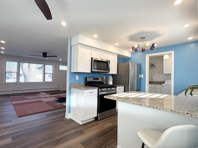 kitchen featuring white cabinets, dark wood-style flooring, stainless steel appliances, a baseboard heating unit, and recessed lighting