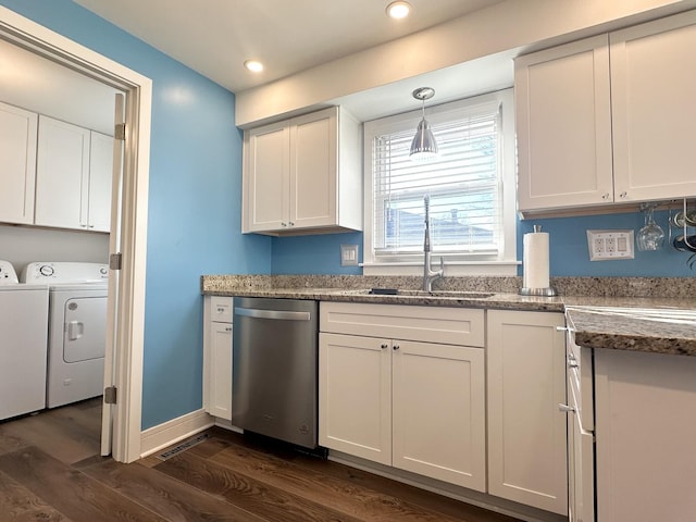 kitchen with a sink, white cabinets, stainless steel dishwasher, dark wood-style floors, and washing machine and clothes dryer