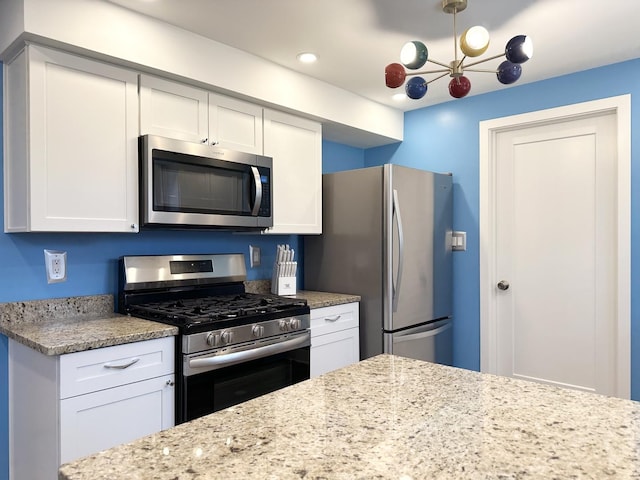 kitchen featuring white cabinetry, stainless steel appliances, light stone counters, and recessed lighting