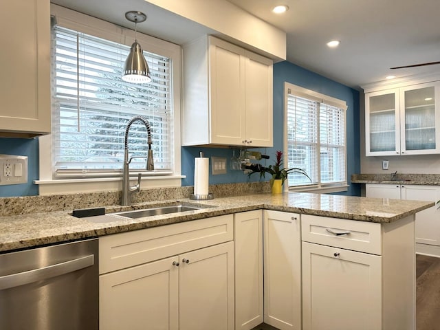 kitchen with glass insert cabinets, white cabinets, dishwasher, and a sink