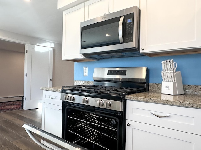 kitchen featuring a baseboard heating unit, appliances with stainless steel finishes, dark wood finished floors, and white cabinetry