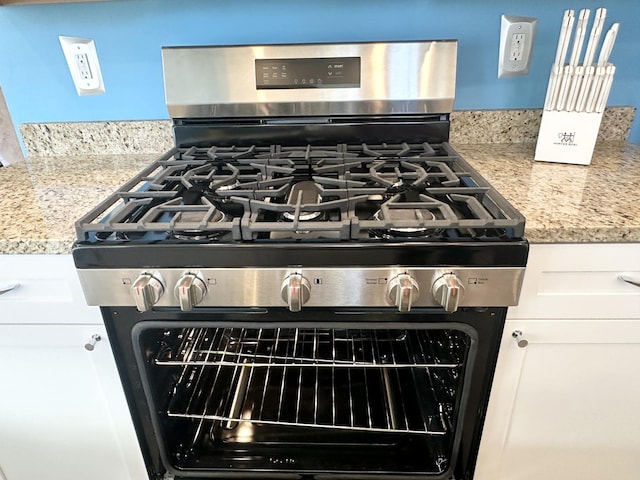 details featuring light stone counters and stainless steel range with gas cooktop