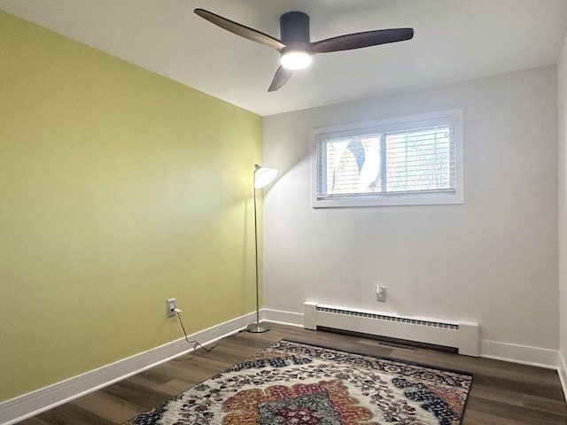 interior space with a baseboard radiator, dark wood finished floors, baseboards, and ceiling fan