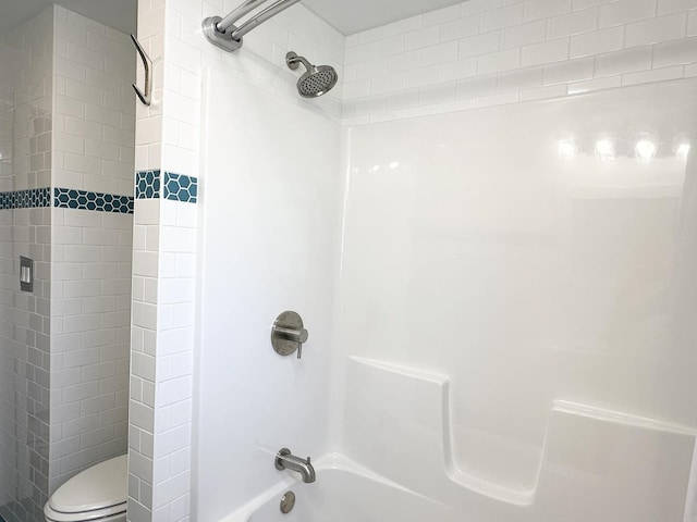 bathroom with washtub / shower combination and toilet