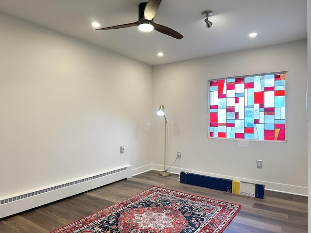 interior space with a baseboard radiator, baseboards, and wood finished floors