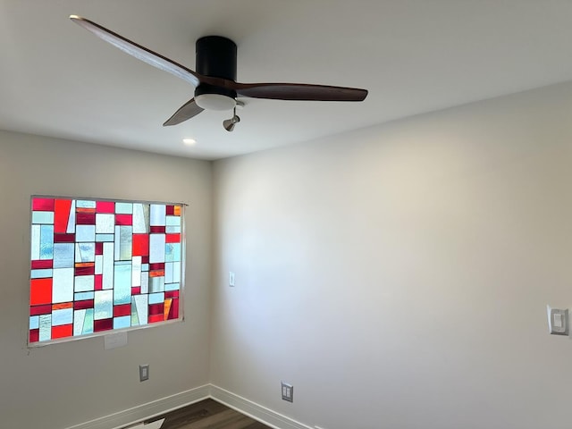 empty room featuring baseboards, dark wood finished floors, and a ceiling fan