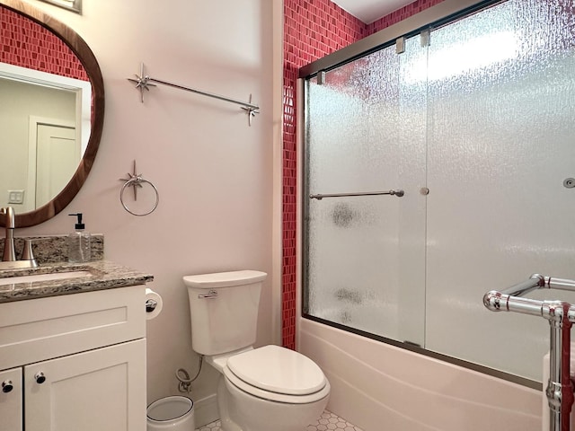 bathroom with toilet, shower / bath combination with glass door, and vanity