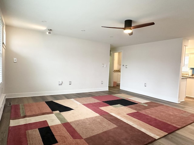 spare room with a ceiling fan, baseboards, and wood finished floors